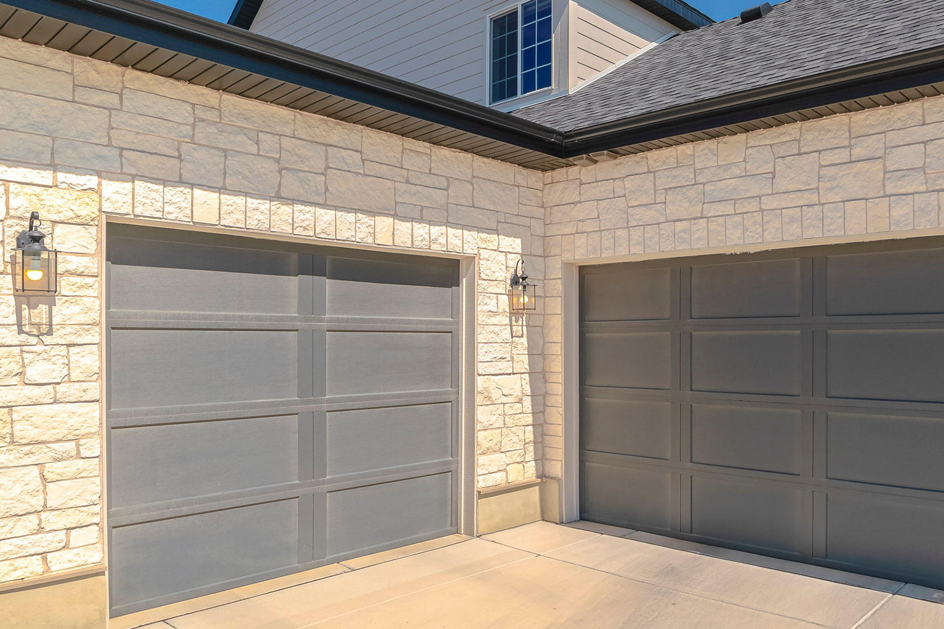 Angled view of twin garage doors with matching exterior lights in West Hills, CA