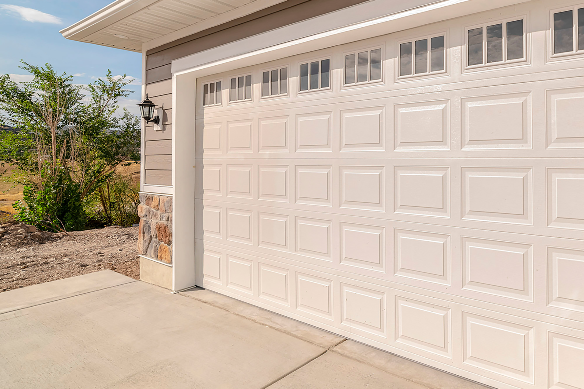 Close-up of raised-panel white garage door with window design in Palmdale, CA