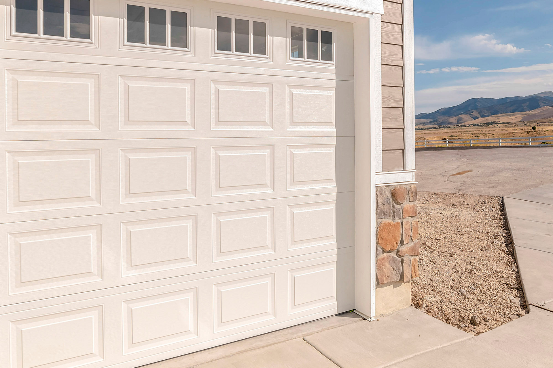 Side view of double white garage doors with stone accents on residential home in Palmdale, CA